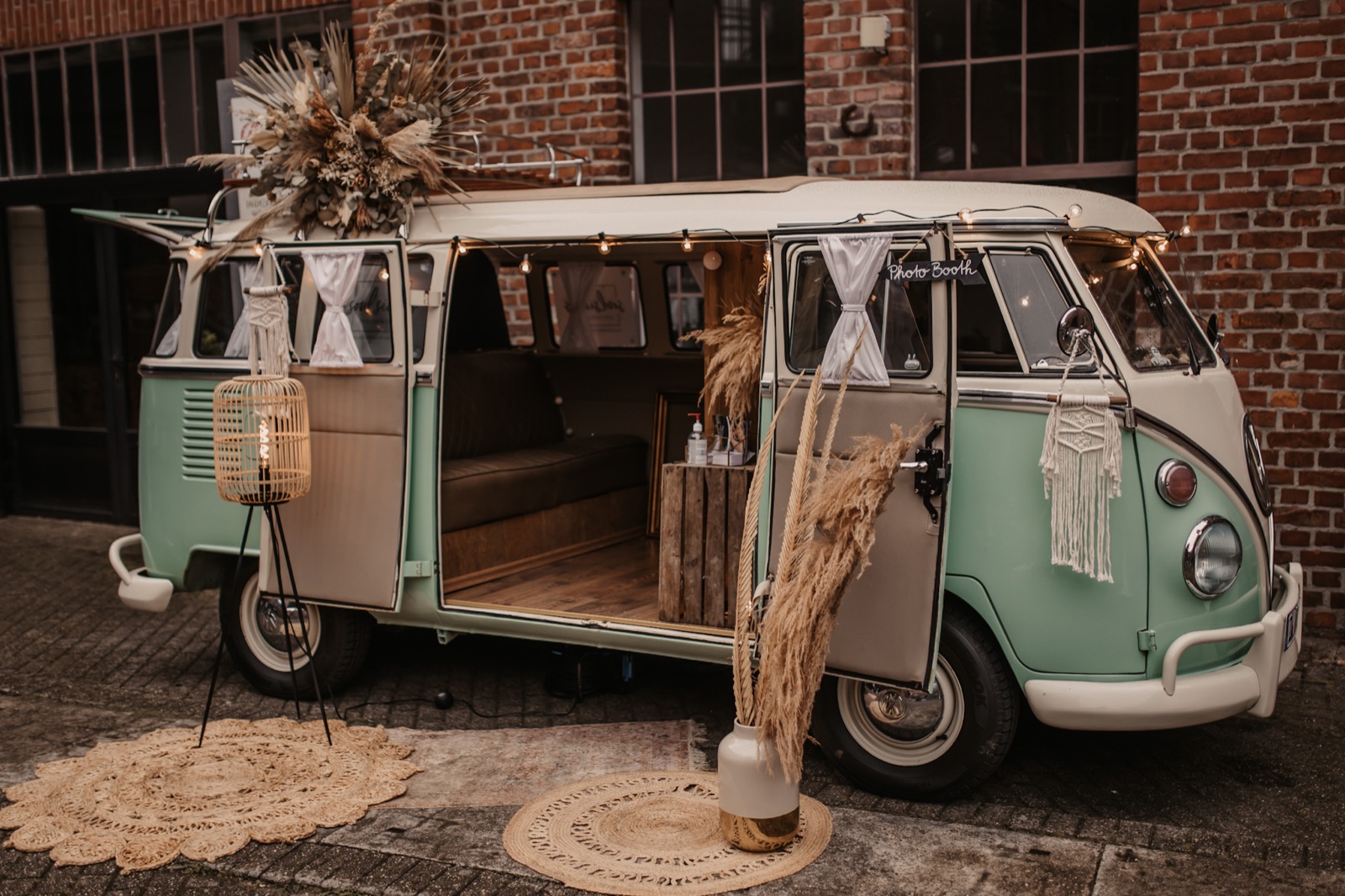 Mintgrüner Fotobulli boho-styled vor Backsteinfassade als Eyecatcher